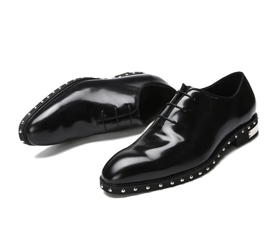 Close-up of metallic studs on black Oxford shoes